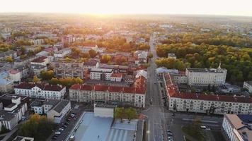 belo vídeo aéreo panorâmico 4k voando drone acima do panorama da cidade do sol siauliai na lituânia com fundo por do sol .. destinos da europa cinematográfica do pôr do sol video