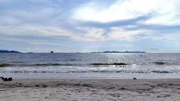 the movement of the sea waves on the beach with sand and a clear cloudy sky video