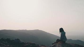 Zoom in view background thoughtful woman sit on ground in scenic mountains alone contemplating. video