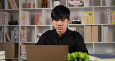 retrato do empresário focado trabalhando laptop no escritório em casa. jovem empresário usando laptop estudando on-line trabalhando em casa na internet, homem digitando no computador navegando na web olhando para a tela.'