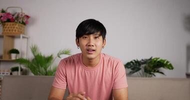 Portrait of Happy young man sitting watching television laughing at home on sofa. Watch a football or soccer match sitting on the couch and cheer and applaud while looking directly at the camera. video