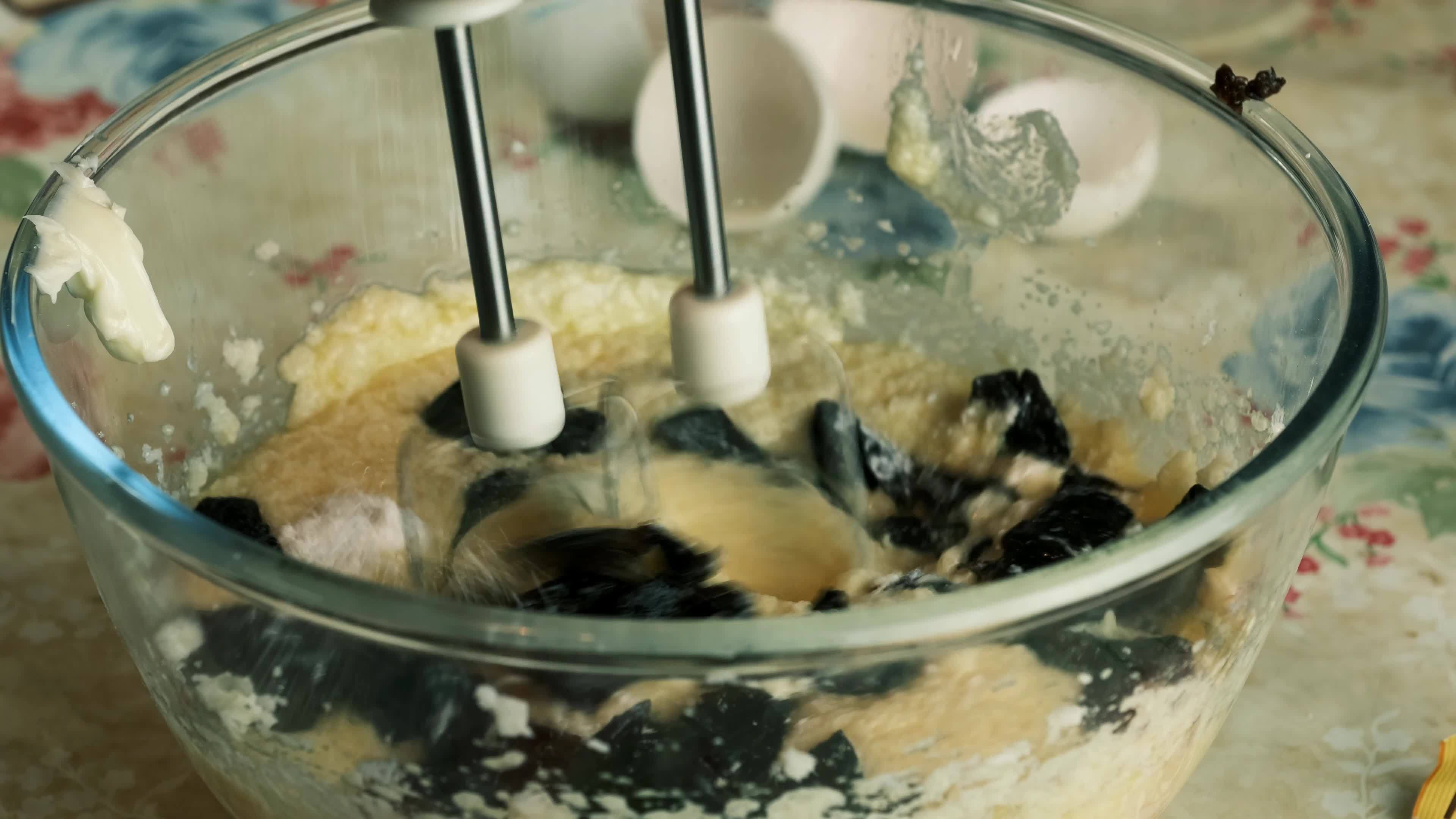 Kneading dough with hand electric mixer. Process of beating the dough