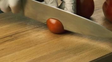les mains des femmes à l'aide d'un couteau de cuisine coupent le poivron rouge frais sur une planche à découper en bois. alimentation saine. poivron rouge haché