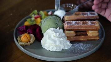 Belgian waffles with ice cream and whipped cream. Slow motion.