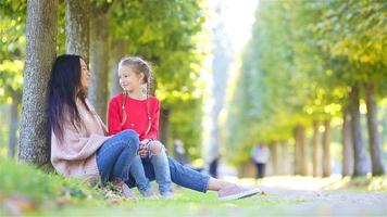 famiglia in autunno. la giovane madre e il bambino si godono il caldo autunno video