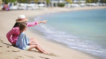 klein meisje en jonge moeder op wit strand video