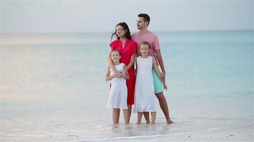 gelukkige mooie familie op wit strand met plezier video