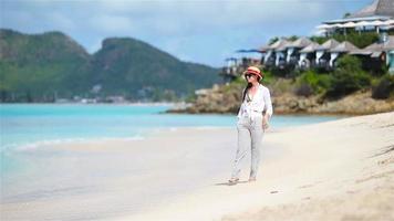 Young beautiful woman on tropical seashore. Fashion girl on the beach