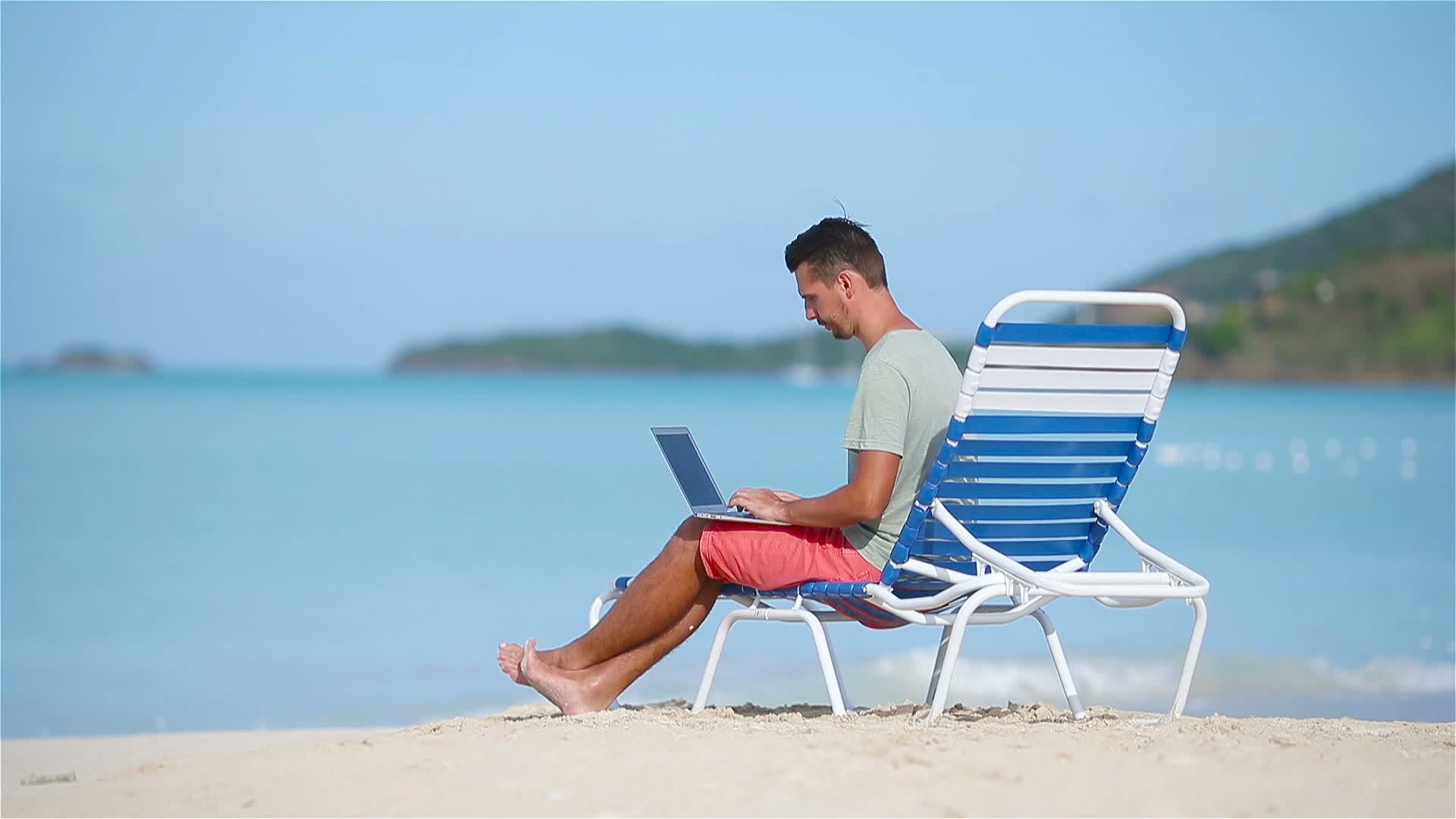 Young man with laptop on tropical caribbean beach. Man sitting on the ...