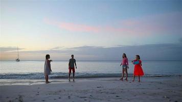 famiglia felice che gioca con il disco volante in spiaggia al tramonto video