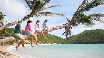 jeune famille en vacances à la plage sur palmier