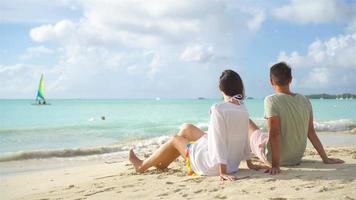 junges Paar am tropischen Strand mit weißem Sand und türkisfarbenem Meerwasser auf der Insel Antigua in der Karibik video