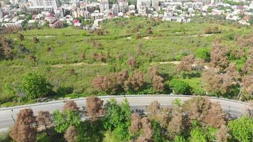 Flygfoto till vägen med en bil och vake distriktets skyskrapor i tbilisi. begreppet stadsliv i Kaukasus och turism i Georgien. 2020 video