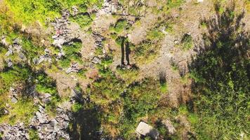 vista aerea verso il basso per coppia silhouette in piedi vicino circondato da rifiuti industriali nella natura verde. video