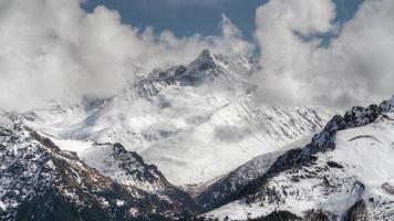 8K Imposing High Snowy Mountain Peaks Behind the Clouds