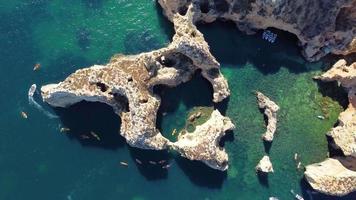 Luftdrohnenaufnahme von Kajaks und Booten, die um die magischen Kalksteinfelsen von Ponta da Piedade herumfahren. erforschung der höhlen und tunnel von lagos, algarve, südlich von portugal. Reisen und Abenteuer. Nomadenleben. video