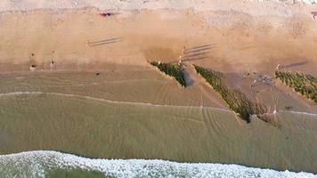 vue aérienne par drone de personnes sur la plage lors d'un magnifique coucher de soleil. des couleurs vibrantes incroyables. Algarve, Portugal. eaux claires. jours fériés et vacances. voyage et aventure. vie nomade. video