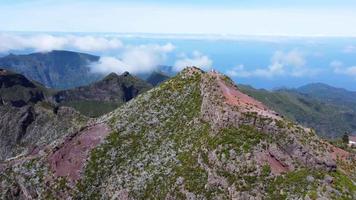 luchtfoto drone uitzicht op de bergtop van pico do areeiro op het eiland madeira, portugal. prachtig landschap. wandelen en nomadische levensstijl. mensen genieten van de piek. bezienswaardigheden bekijken. video