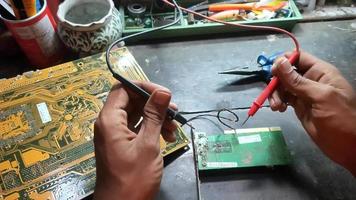 mann, der elektronik in einer werkstatt voller mechanischer ausrüstung repariert video