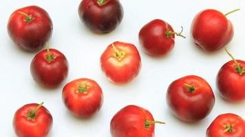 Verse biologische acerola met groene bladeren, geïsoleerd op een witte achtergrond met uitknippad video