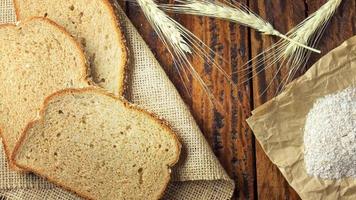 Volkoren gesneden biologisch brood bestaande uit haver en lijnzaad op houten tafel. gezond dieet video