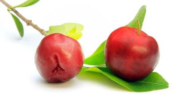 Verse biologische acerola met groene bladeren, geïsoleerd op een witte achtergrond met uitknippad video