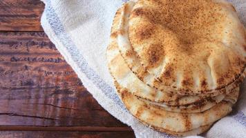 pan de pita aislado en una mesa rústica de madera.comida tradicional y típica de la cocina árabe video