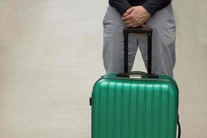 Waiting at the airport. The concept of summer vacation, a traveler with a suitcase in the waiting area of the airport terminal. Selective focus. photo