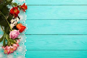 Frame of flowers and towels in polka dots on blue wooden background. Top view and selective focus. Copy space photo