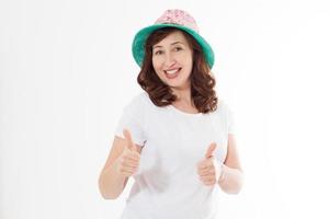 Happy surprised and excited woman in summer hat and template white t shirt isolated on white background. Holiday vacation with big thumb up . Fun summertime. Copy space, blank place on tshirt. Banner photo
