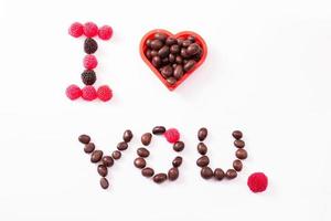 Candy and sweets isolated on white background. Heart shape. Top view. Selective focus. Copy space and mock up photo