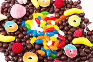 caramelos de colores, piruletas y dulces aislados en fondo blanco. vista superior. enfoque selectivo. foto