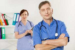 Doctor and nurse posing in medical office close up. Two doctors closeup in clinic photo