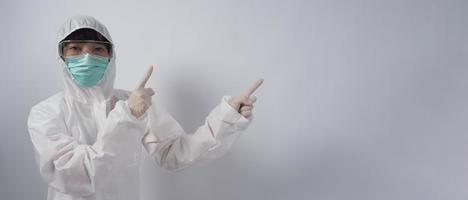 Doctor in PPE suit gesture make hand sign. Represent victory win over virus. photo