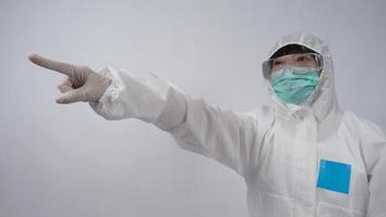 Doctor in PPE suit gesture make hand sign. Represent victory win over virus. photo