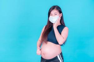 Pregnant Asian women need to use masks to protect against dust pollution and to prevent infection from viruses photo