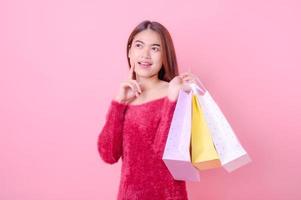 hermosas mujeres asiáticas son felices cuando piensan en comprar los productos que quieren durante una promoción con descuento foto