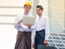 Young Burmese businessmen meet and talk about their business through Internet search, During working hours outside the office photo