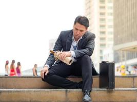 hombre de negocios sentado en un parque al aire libre y estresado por el fracaso del trabajo empresarial foto