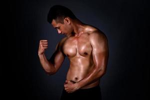 un hombre asiático fuerte levantó los brazos para mostrar sus músculos fuertes y hermosos del ejercicio foto