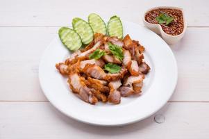 chuletas de cerdo crujientes, listas para comer con verduras frescas y salsa picante foto