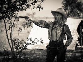 A young cowgirl stand with a gun to guard the safety of the camp in the western area photo