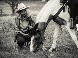 Cowgirl and the horse are deeply bonded to each other in love because of their distressed relationships in a wild outlaw photo