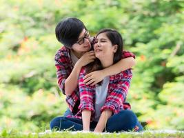 parejas de mujeres asiáticas lgbt sentadas y relajadas en el jardín y abrazándose con amor y felicidad foto