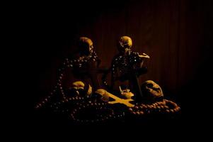 Still life art of a human skull and bead on a black background photo