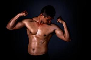 un hombre asiático fuerte levantó los brazos para mostrar sus músculos fuertes y hermosos del ejercicio foto