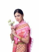 una encantadora mujer tailandesa con un antiguo vestido tailandés sosteniendo una flor de loto que se usa para adorar a los monjes religiosos foto