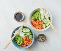 poke bowl de salmón con pescado fresco, arroz, pepino, aguacate foto