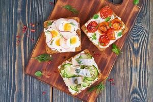 Smorrebrod - traditional Danish sandwiches. Black rye bread with fish, herring, photo