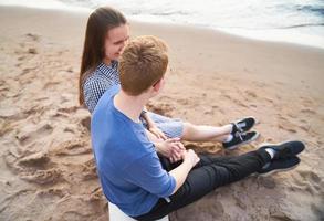 chica y chico charlando, fondo de playa, concepto de amor adolescente foto